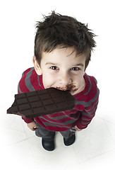 Image showing Smiling little boy eating chocolate