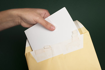 Image showing Hand that open a letter from brown envelope