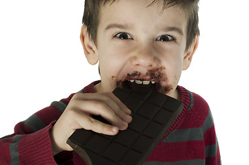 Image showing Smiling little boy eating chocolate