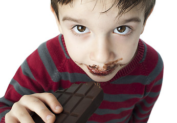 Image showing Smiling little boy eating chocolate