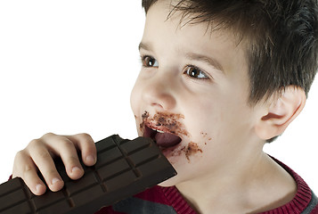 Image showing Smiling little boy eating chocolate