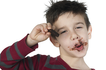 Image showing Smiling little boy eating chocolate