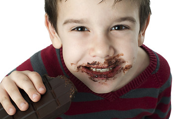 Image showing Smiling little boy eating chocolate