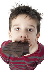 Image showing Smiling little boy eating chocolate