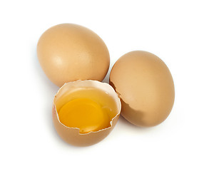 Image showing Tree whole eggs and another broken in half raw egg