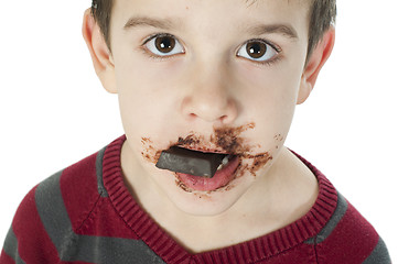 Image showing Smiling little boy eating chocolate