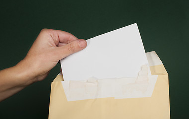 Image showing Hand that open a letter from brown envelope