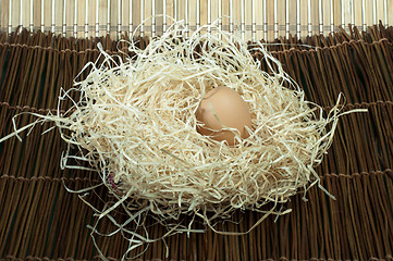 Image showing Raw eggs in straw