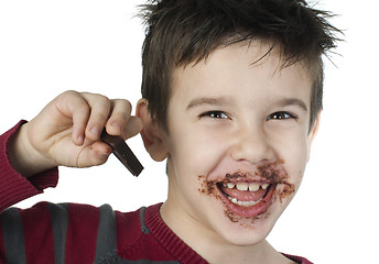 Image showing Smiling little boy eating chocolate