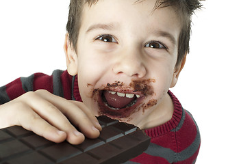 Image showing Smiling little boy eating chocolate