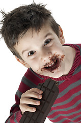 Image showing Smiling little boy eating chocolate