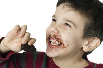 Image showing Smiling little boy eating chocolate