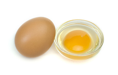 Image showing One whole egg and another broken in half raw egg