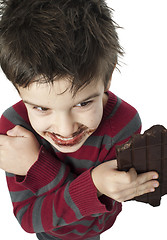 Image showing Smiling little boy eating chocolate