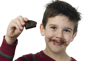 Image showing Smiling little boy eating chocolate