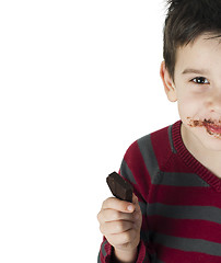 Image showing Smiling little boy eating chocolate