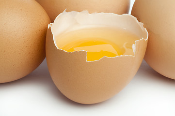 Image showing Tree whole eggs and another broken in half raw egg