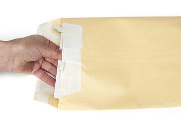 Image showing Hand that open a letter from brown envelope