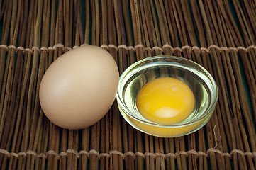 Image showing Broken in half raw egg and yolk inside