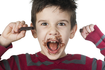 Image showing Smiling little boy eating chocolate