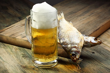 Image showing Glass with beer and dried fish. 