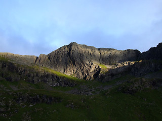 Image showing Sunny patch on a dark mountain