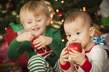 Image showing Mixed Race Baby and Young Boy Enjoying Christmas Morning Near Th