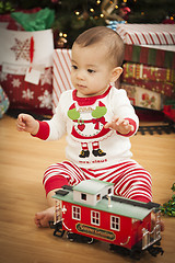 Image showing Infant Mixed Race Baby Enjoying Christmas Morning Near The Tree