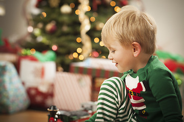 Image showing Young Boy Enjoying Christmas Morning Near The Tree