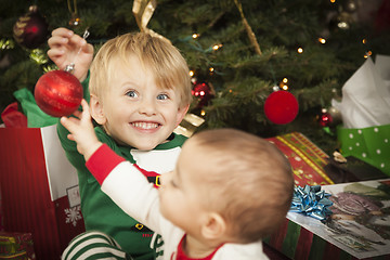 Image showing Mixed Race Baby and Young Boy Enjoying Christmas Morning Near Th