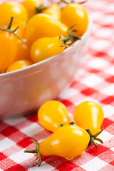 Image showing yellow tomatoes on picnic tablecloth