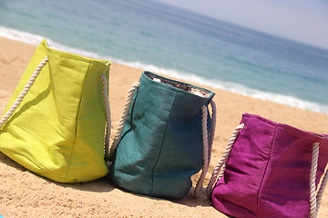 Image showing Summer holiday ? three vivid bags on the seacoast