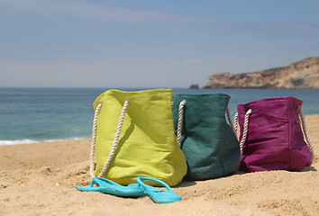 Image showing Summer holiday ? three vivid bags on the seacoast