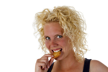 Image showing Young woman eating cookie