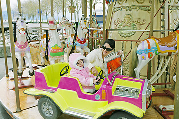 Image showing Woman with little child on carousel