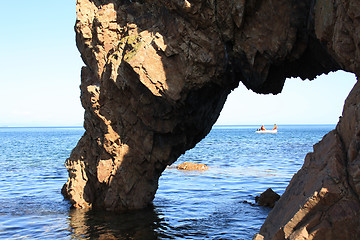 Image showing Kind on a fishing boat from under rocks