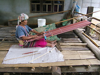 Image showing Woman working on a traditional handloom waeving