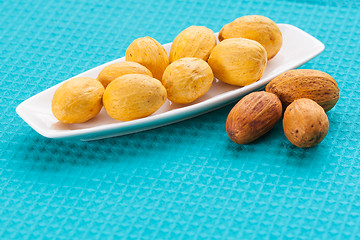 Image showing Nuts on a white saucer and near it