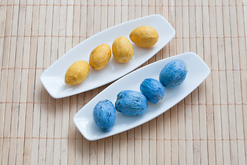 Image showing painted yellow and blue nuts on plates