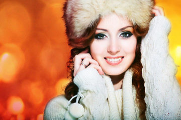 Image showing beautiful girl with winter fur cap on bright background