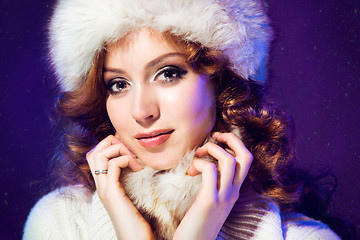 Image showing beautiful girl with winter fur cap on purple 