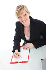 Image showing Businesswoman writing on a clipboard