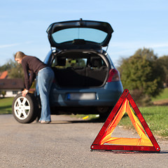 Image showing Changing the tire on a broken down car