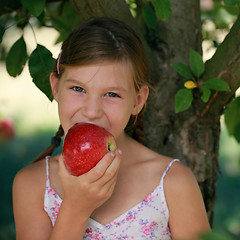 Image showing Little girl biting into an apple