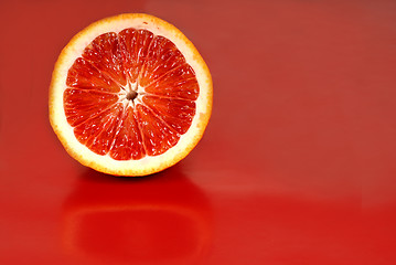 Image showing Half of a blood orange on a red background