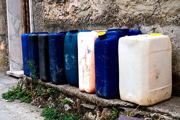 Image showing Row of colorful Jerry Cans on the street - Italy