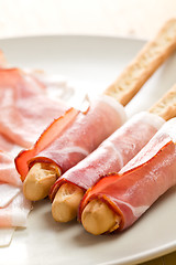Image showing grissini sticks with ham