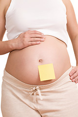 Image showing pregnant women with notepaper on her belly