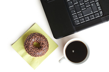 Image showing break in the  office . doughnut on laptop keyboard