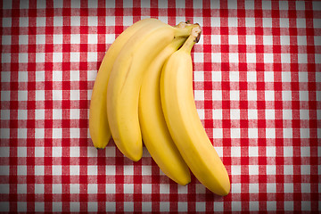 Image showing yellow bananas on checkered tablecloth